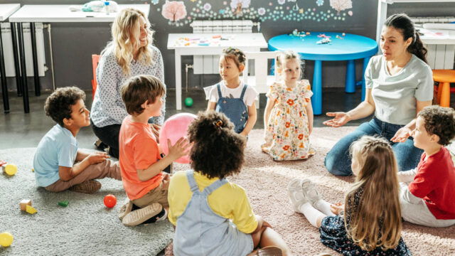 Nursery group and workers sit and talk together