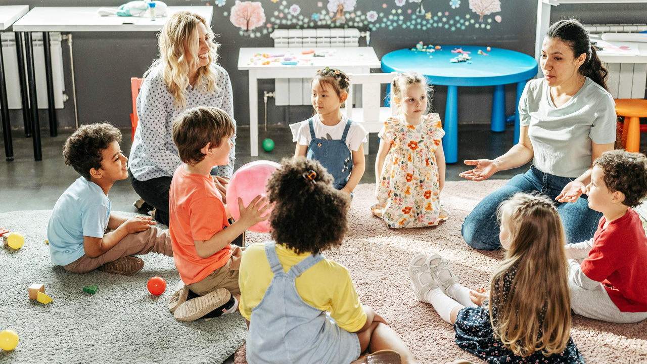 Nursery group and workers sit and talk together