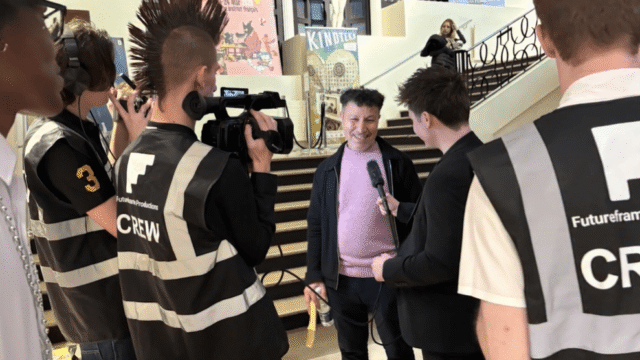 Young Futureframe Productions crew members filming and interviewing a man at the South Ken Kids Festival