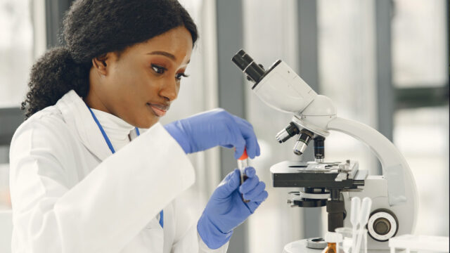 Lab technician using microscope