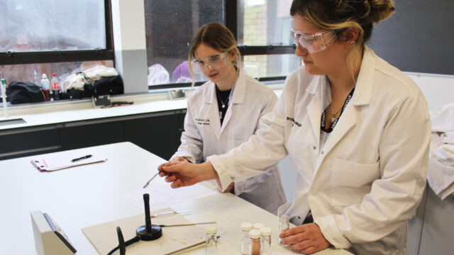 Science students test bunsen burner in laboratory