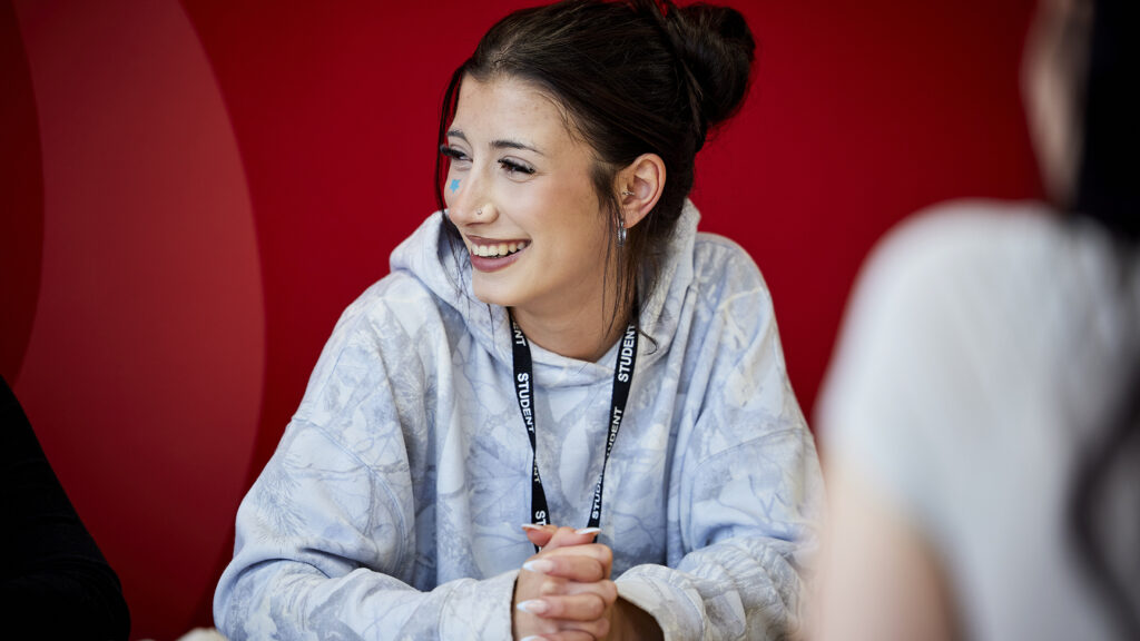 Student smiling and laughing while speaking with friends
